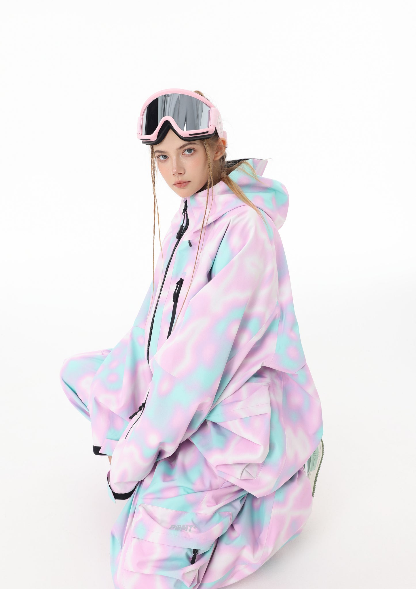 Person wearing a pastel-colored onesie with matching goggles on a white background