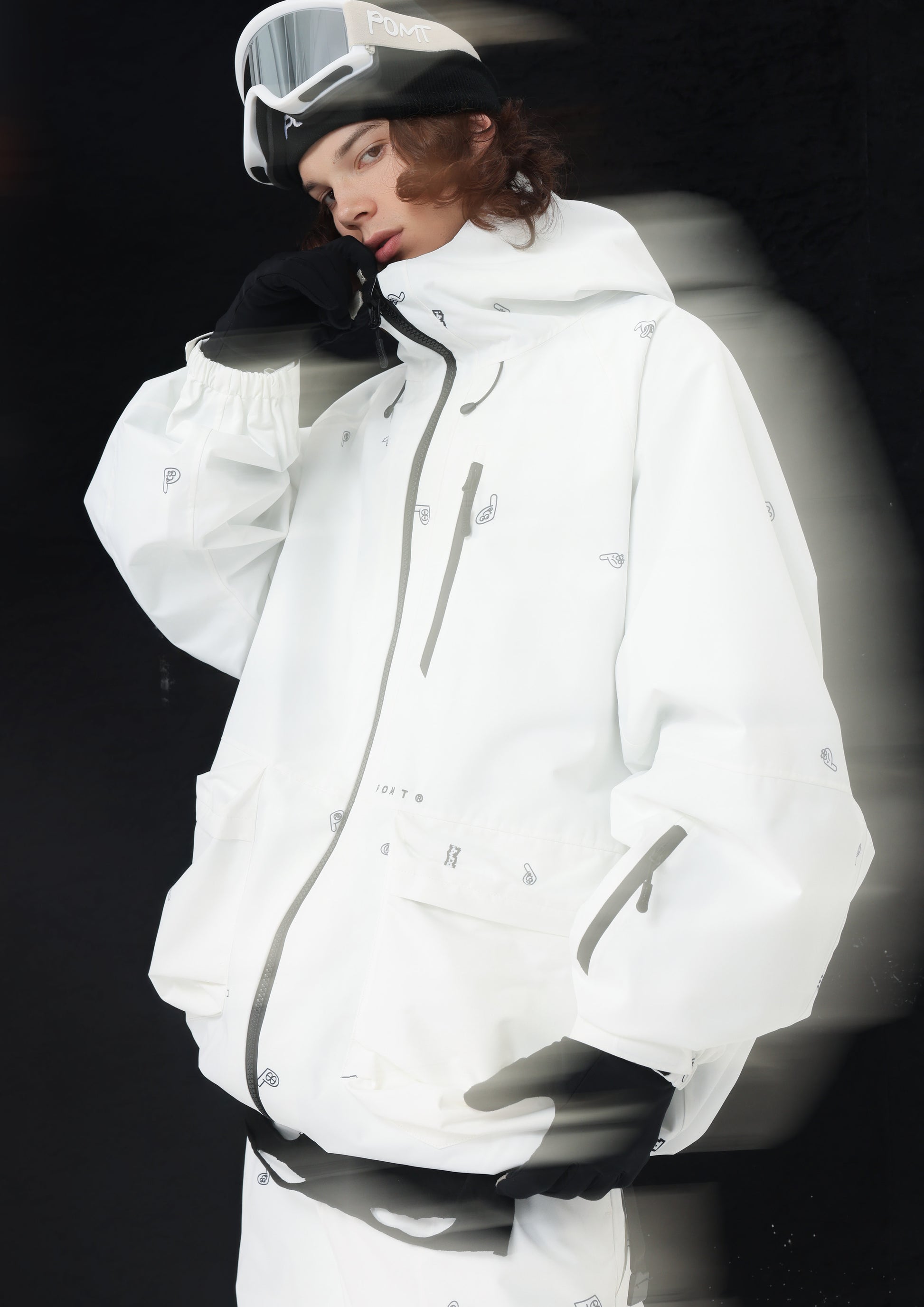 Person wearing a white snow jacket in black background